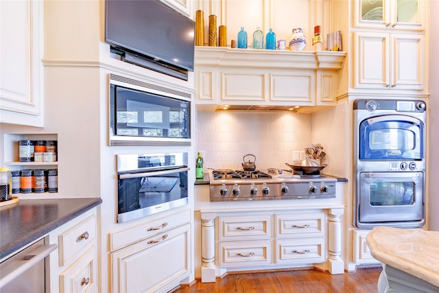 kitchen with stainless steel appliances, light hardwood / wood-style flooring, and tasteful backsplash