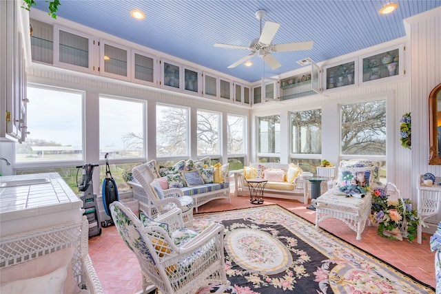 sunroom / solarium featuring ceiling fan