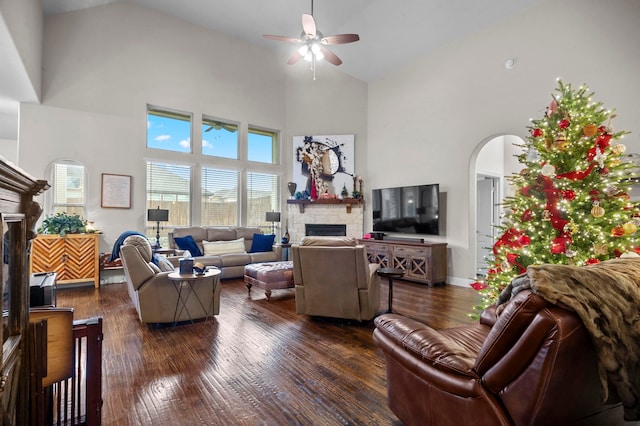 living room with dark hardwood / wood-style floors, a fireplace, and high vaulted ceiling