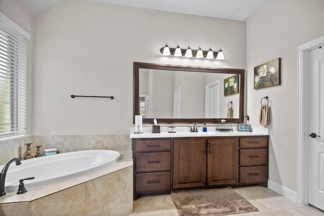 bathroom with tile patterned flooring, vanity, and a relaxing tiled tub