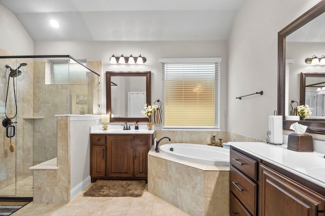 bathroom with vanity, independent shower and bath, a wealth of natural light, and lofted ceiling