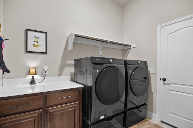 clothes washing area featuring cabinets and independent washer and dryer