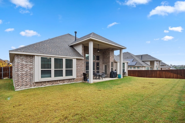 back of property featuring a lawn and a patio