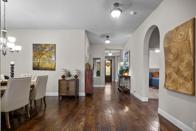 foyer with dark hardwood / wood-style flooring and an inviting chandelier