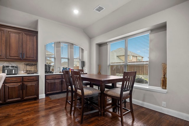 dining space with plenty of natural light, dark hardwood / wood-style flooring, and vaulted ceiling