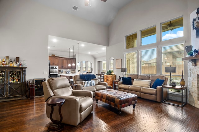 living room featuring ceiling fan, a fireplace, high vaulted ceiling, and dark hardwood / wood-style floors