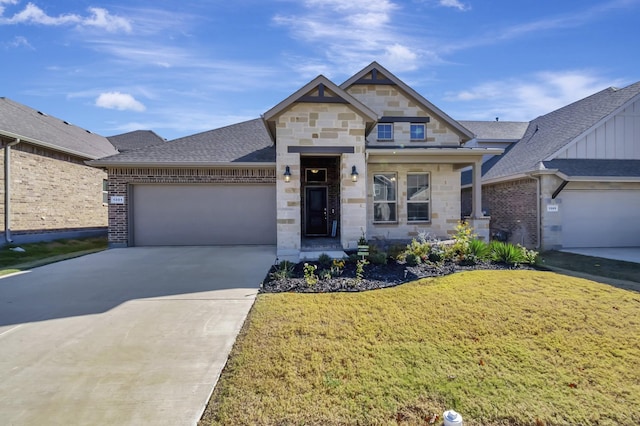 view of front of property with roof with shingles, concrete driveway, a garage, stone siding, and a front lawn