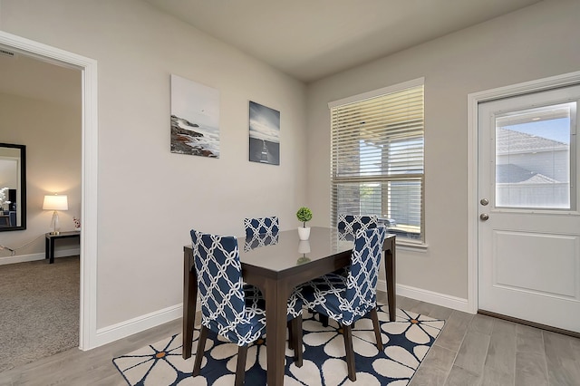 dining room with baseboards and wood finished floors