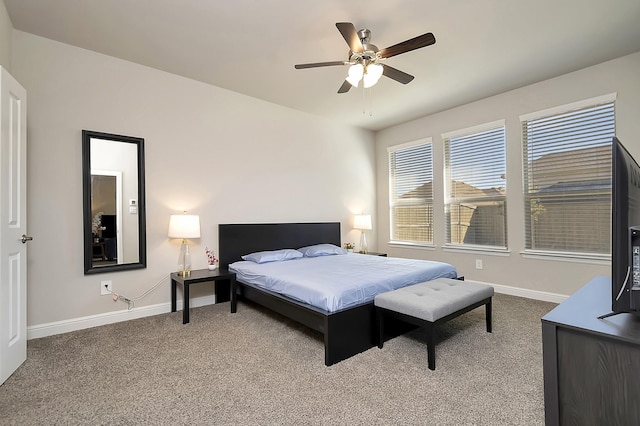 carpeted bedroom with ceiling fan and baseboards