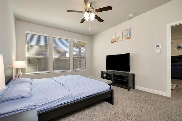 bedroom with light carpet, ceiling fan, and baseboards