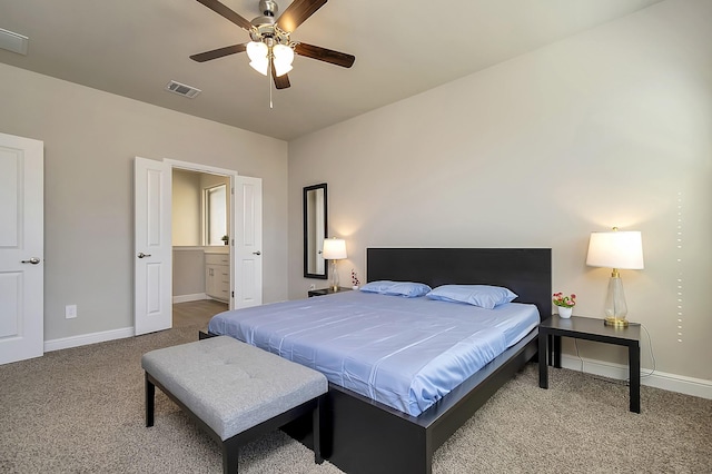 carpeted bedroom with a ceiling fan, visible vents, baseboards, and ensuite bathroom