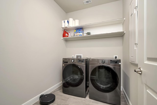 washroom featuring laundry area, visible vents, baseboards, and separate washer and dryer