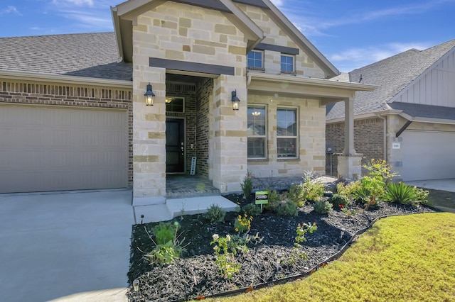 view of exterior entry featuring stone siding, driveway, and an attached garage