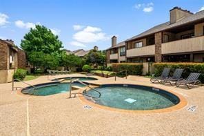 view of swimming pool with a community hot tub and a patio area