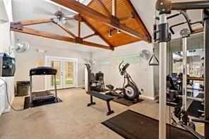 workout area with carpet floors, high vaulted ceiling, french doors, and ceiling fan