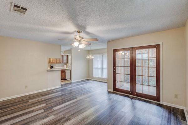 unfurnished living room with ceiling fan with notable chandelier, dark hardwood / wood-style floors, and a textured ceiling