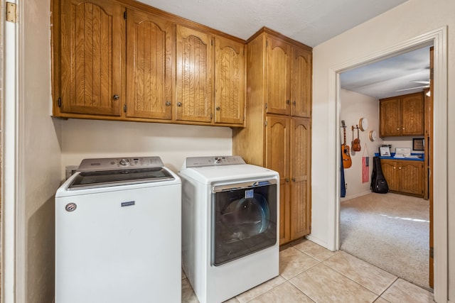 laundry area with cabinets, ceiling fan, washing machine and dryer, and light tile patterned floors