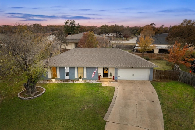 ranch-style house with a shingled roof, concrete driveway, an attached garage, a front yard, and fence