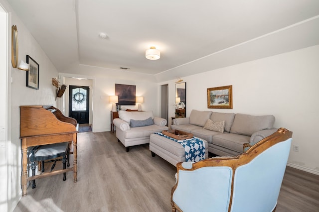 living room featuring visible vents, baseboards, and wood finished floors