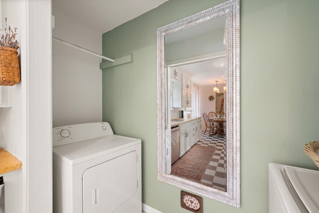 washroom with laundry area, a chandelier, washer and clothes dryer, and a sink