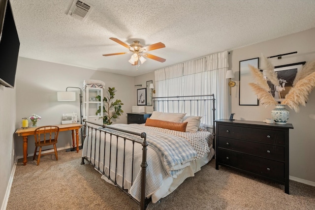 carpeted bedroom with visible vents, ceiling fan, a textured ceiling, and baseboards