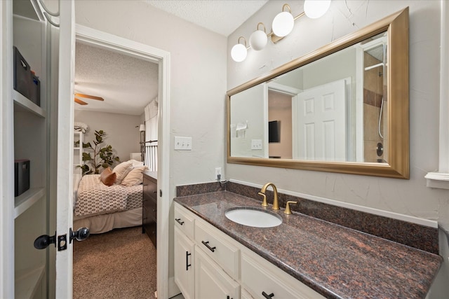 bathroom featuring ensuite bath, ceiling fan, a textured ceiling, and vanity