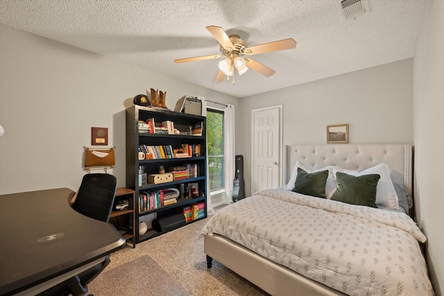 carpeted bedroom featuring a ceiling fan, visible vents, and a textured ceiling