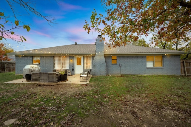 back of property at dusk with a patio area, fence, an outdoor hangout area, and brick siding