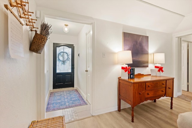 foyer featuring light wood-style flooring, stairway, and baseboards