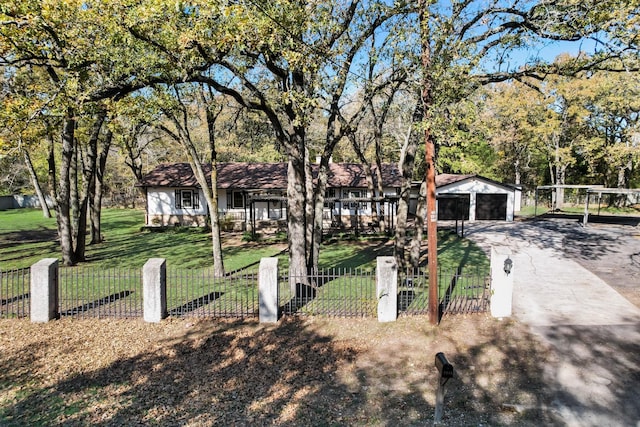 single story home featuring an outbuilding, a garage, and a front lawn