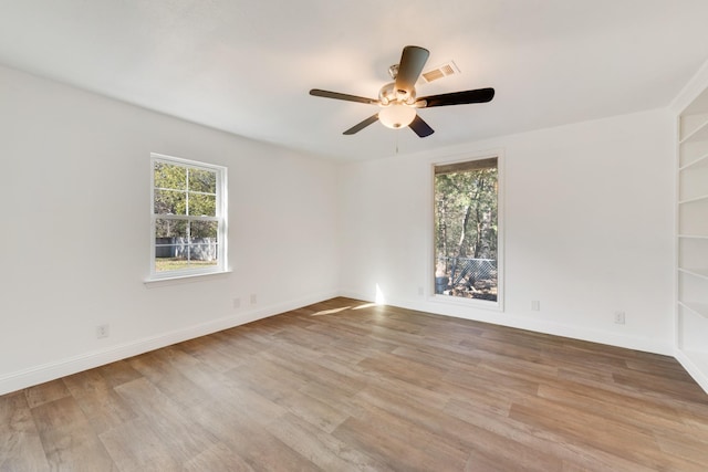 spare room featuring plenty of natural light, ceiling fan, and light wood-type flooring