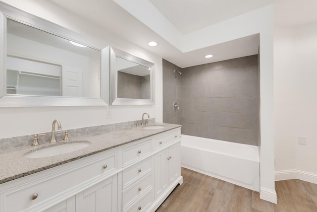 bathroom with vanity, wood-type flooring, and tiled shower / bath combo