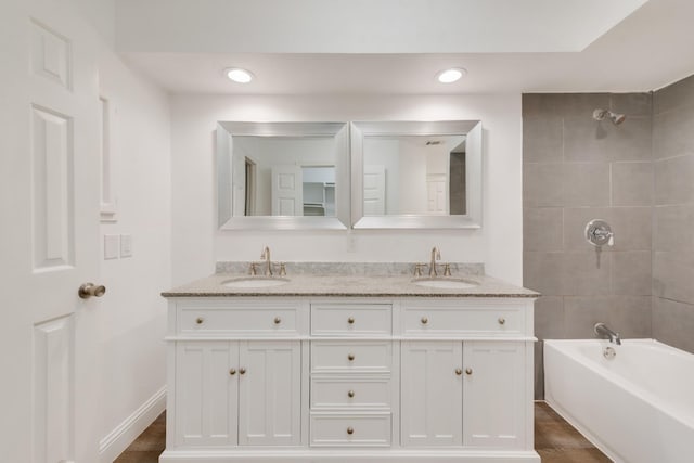 bathroom featuring hardwood / wood-style floors, vanity, and tiled shower / bath