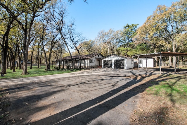 view of front of home featuring a garage and an outbuilding