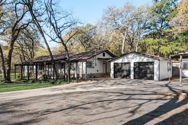 view of front of home with a garage and an outbuilding