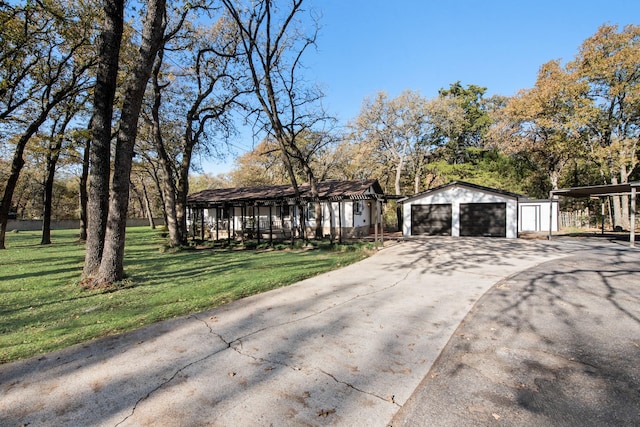 view of front of house featuring a front yard, an outbuilding, and a garage