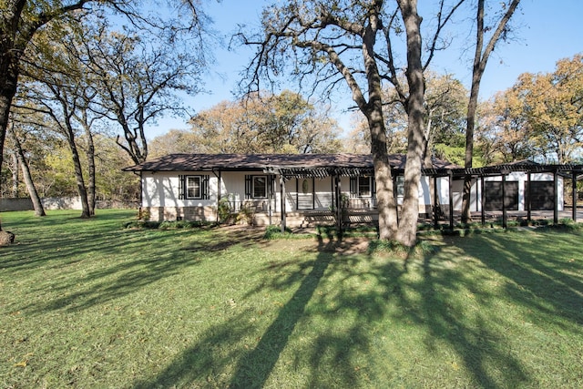 view of front facade featuring a front lawn and a pergola