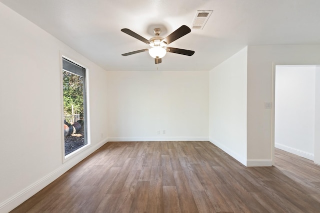 empty room featuring baseboards, visible vents, and wood finished floors