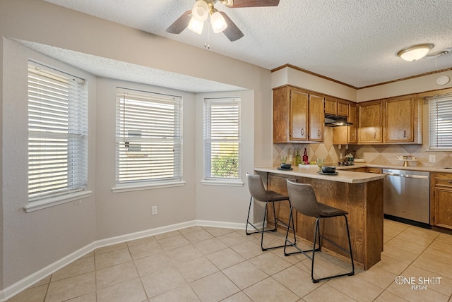 kitchen with dishwasher, a kitchen bar, kitchen peninsula, and a wealth of natural light