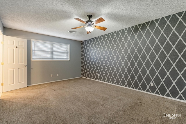 carpeted empty room featuring ceiling fan and a textured ceiling