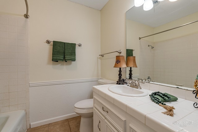 full bathroom with toilet, vanity, tile patterned floors, and tiled shower / bath