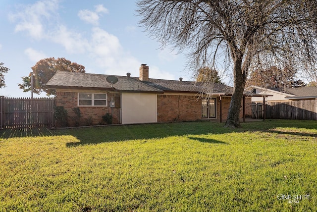 rear view of property with a lawn