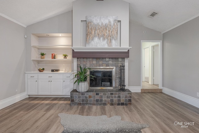 unfurnished living room featuring crown molding, a fireplace, light hardwood / wood-style floors, and a textured ceiling