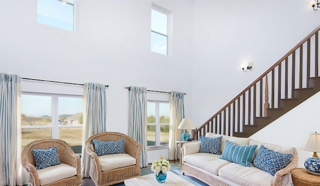 living room featuring hardwood / wood-style flooring and a towering ceiling