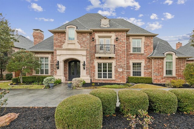 french country home featuring french doors and a balcony