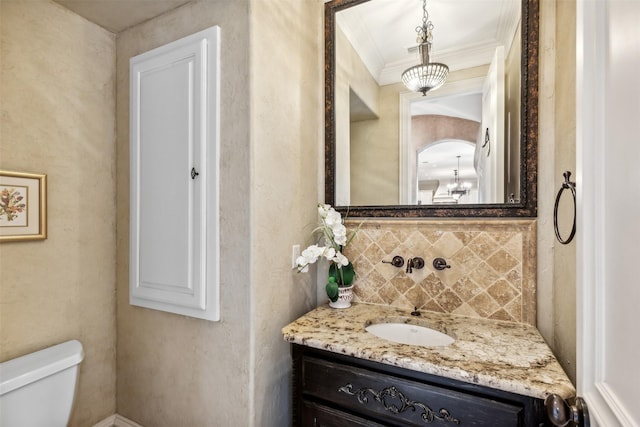 bathroom featuring vanity, tasteful backsplash, toilet, and ornamental molding