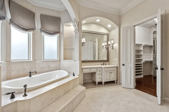 bathroom featuring tile patterned floors, vanity, ornamental molding, and tiled tub