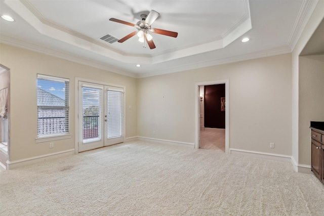 interior space featuring light carpet, a raised ceiling, ceiling fan, and crown molding