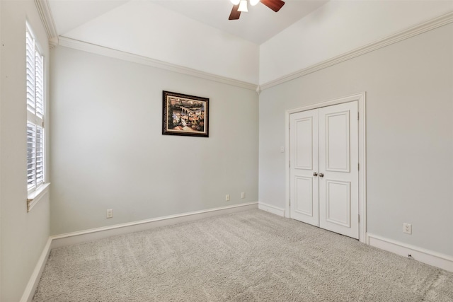 unfurnished bedroom featuring carpet flooring, multiple windows, ceiling fan, and crown molding