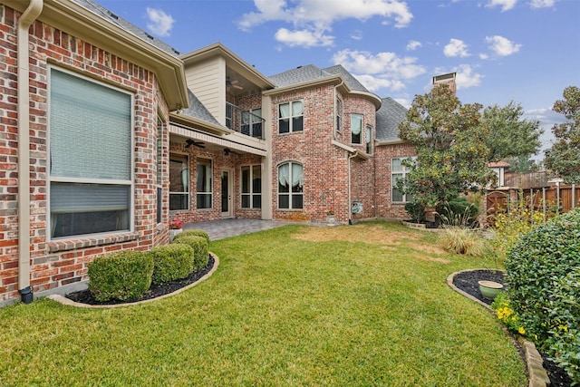 back of house featuring a yard, a balcony, ceiling fan, and a patio area